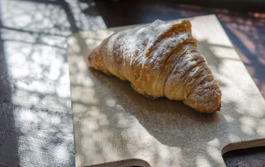 reshly baked croissants on wooden cutting board