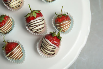 Dessert stand with chocolate covered strawberries on grey background, top view