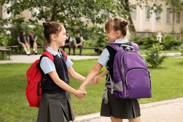 Little girls in stylish school uniform outdoors