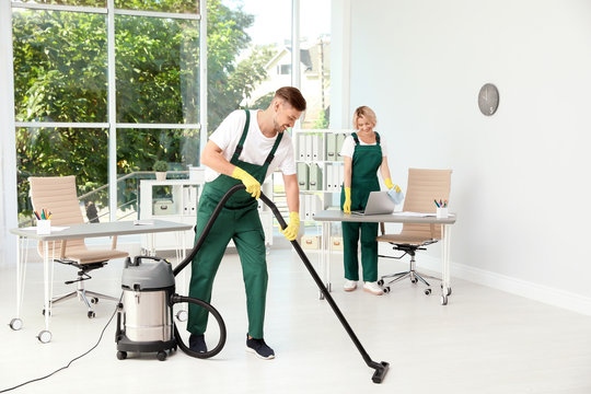 Team Of Janitors In Uniform Cleaning Office