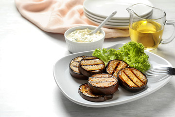 Plate with fried eggplant slices on table