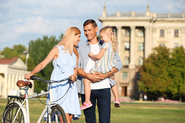 Happy family with bicycle outdoors on sunny day