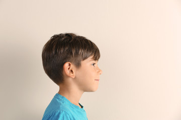 Cute little boy with hearing problem on light background. Space for text