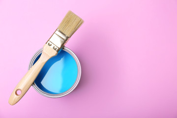 Paint can and brush on pink background, top view. Space for text