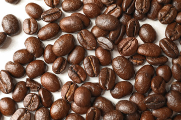 Roasted coffee beans on white background, top view