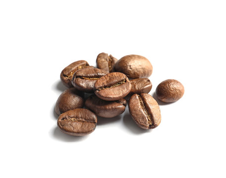 Pile of roasted coffee beans on white background