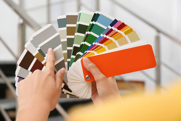 Female interior designer with color palette samples indoors, closeup
