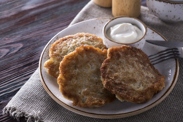 Fried potato pancakes with sour cream on a plate