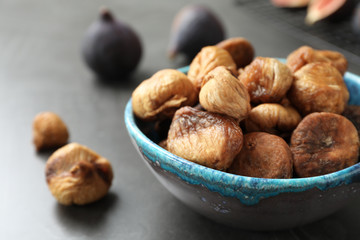 Bowl with delicious dried figs on grey table, closeup. Organic snack