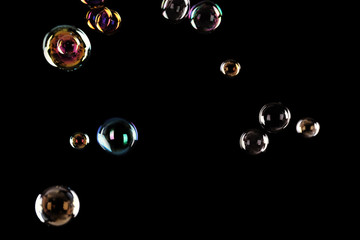 Beautiful translucent soap bubbles on dark background