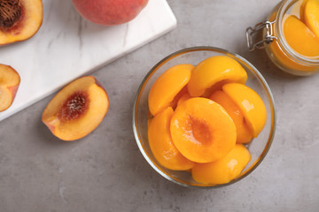 Naklejka na ściany i meble Flat lay composition with canned and fresh peaches on grey background