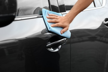 Man washing car door with rag, closeup