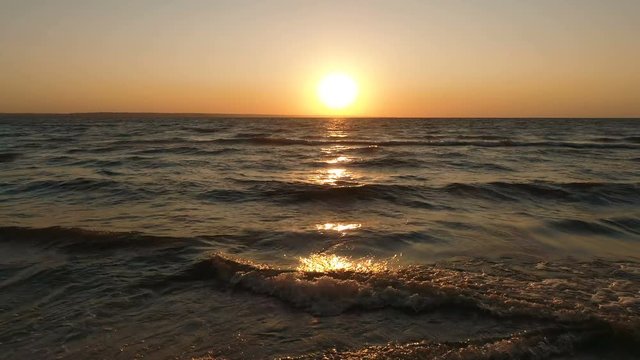 Aerial drone footage of sea waves moving moves near the shore. Beautiful view of seascape during sunset. 4K Resolution.
