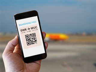 mobile phone in hand with boarding pass for flight.
