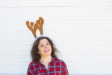 Portrait of cheerful woman with Christmas deer horns on white background with copy space