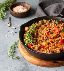 Pan of italian sauce bolognese with thyme on grey concrete background. Copy space.