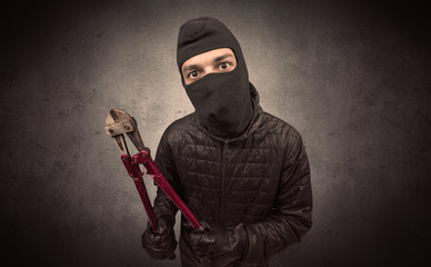 Burglar standing in black clothes and balaclava on his head.