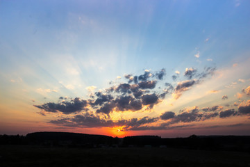 sunset dawn sun rays over the city sky field of flowers