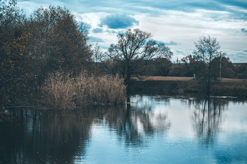 autumnal beautiful landscape, blue sky and autumn trees with reflection in the river