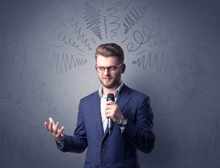 Businessman speaking into microphone with scribbles over his head 