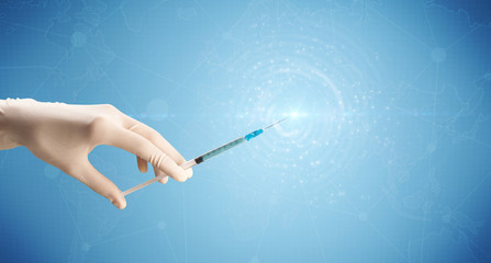 Female doctor hand holding syringe with blue background and shine