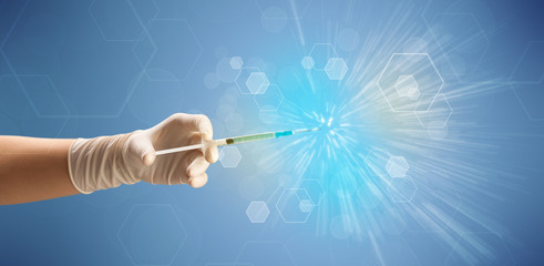 Fototapeta premium Female doctor hand holding syringe with shiny background