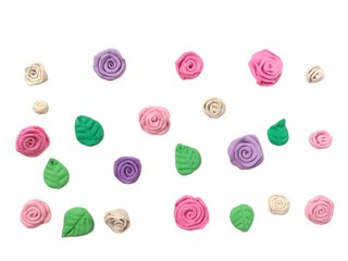 Beautiful pastel flower and leaf made from plasticine clay are arranged disrupted on white background, wallpaper cute colorful rose dough