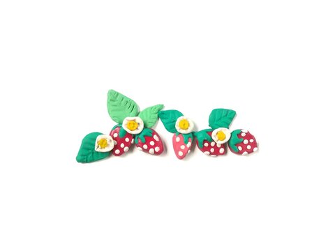 Beautiful branch of strawberry with leaf and flower made from plasticine clay are arrange line on white background, delicious fruit dough