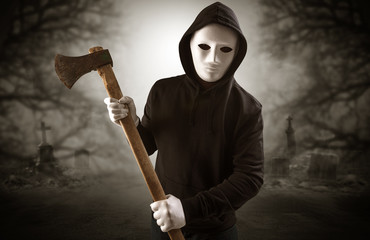 Armed aggressive hunter in abandoned thick forest graveyard concept
