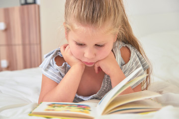 Girl reading lying on bed