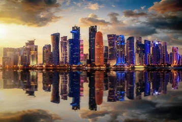 Fotobehang Die urbane Skyline von Doha in Katar bei Sonnenuntergang mit Reflektionen in der Bucht © moofushi