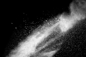 Bizarre forms of white powder explosion cloud against black background.White dust particles splash.