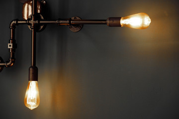 two orange bulb lamp with black metal pipe in the dark night on grey wall interior background
