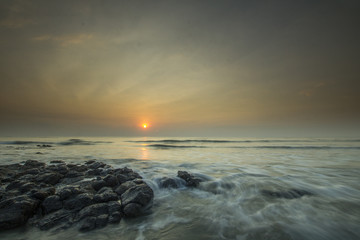 Glorious morning sunrise at Pantai Batu Hitam (Batu Hitam Beach), Kuantan, Pahang. Awesome clouds with ray of light visible.