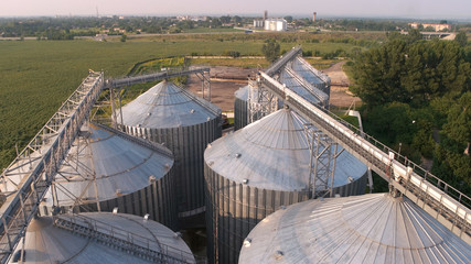Grain bin among wheat fields. Grain elevators agriculture farming storage bin tanks.