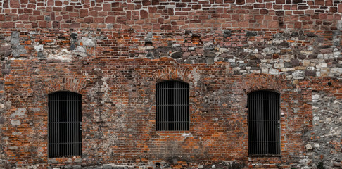 Backsteinfassade mit vergitterten Fenstern