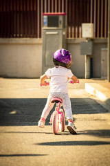 little girl with helmet, playing with the balance bike
