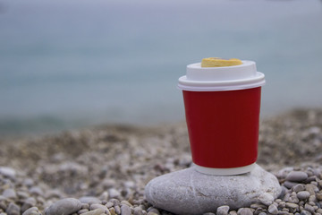 coffee in a red glass on the seashore