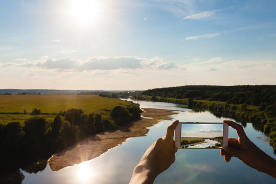 Someone using smartphone to taking photo of summer landscape