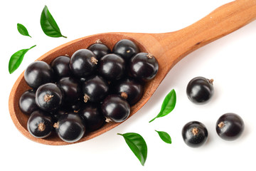 black currant with leaf in wooden spoon isolated on white background. Top view. Flat lay pattern