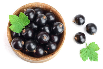 black currant with leaf in wooden bowl isolated on white background. Top view. Flat lay pattern