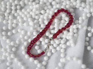 beautiful red seed beads bracelet on white background