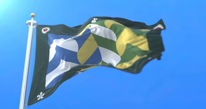 Flag of the english county of Cumbria in the North West of England waving at wind with blue sky in slow. Loop