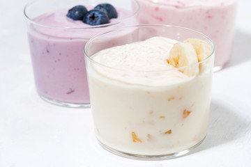 sweet yoghurts with fruits and berries on white background, closeup