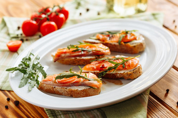 Whole grain bread with avocado paste and salmon decorated with arugula. Top view