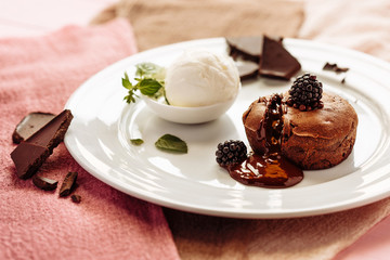 chocolate Fondan with syrup and ice-cream on a plate decorated with mint leaves