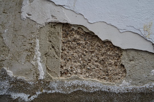 Mur blanc abîmé, ciment à nu