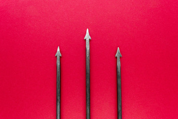 Old, rusty  and metal trident with three spikes on red background surface