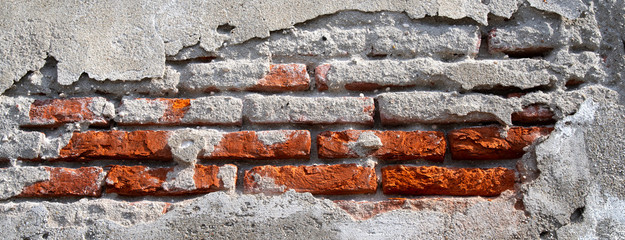 Backsteinmauer mit bröckelndem Verputz