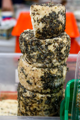 Gourmet white goat cheese covered with herbs and mold, small wheels are place on each other